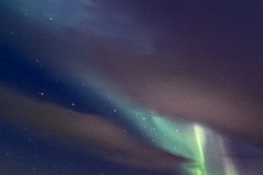 Iceland Aurora Beams Through Clouds